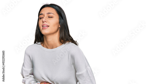 Young hispanic girl wearing casual clothes with hand on stomach because nausea, painful disease feeling unwell. ache concept. © Krakenimages.com