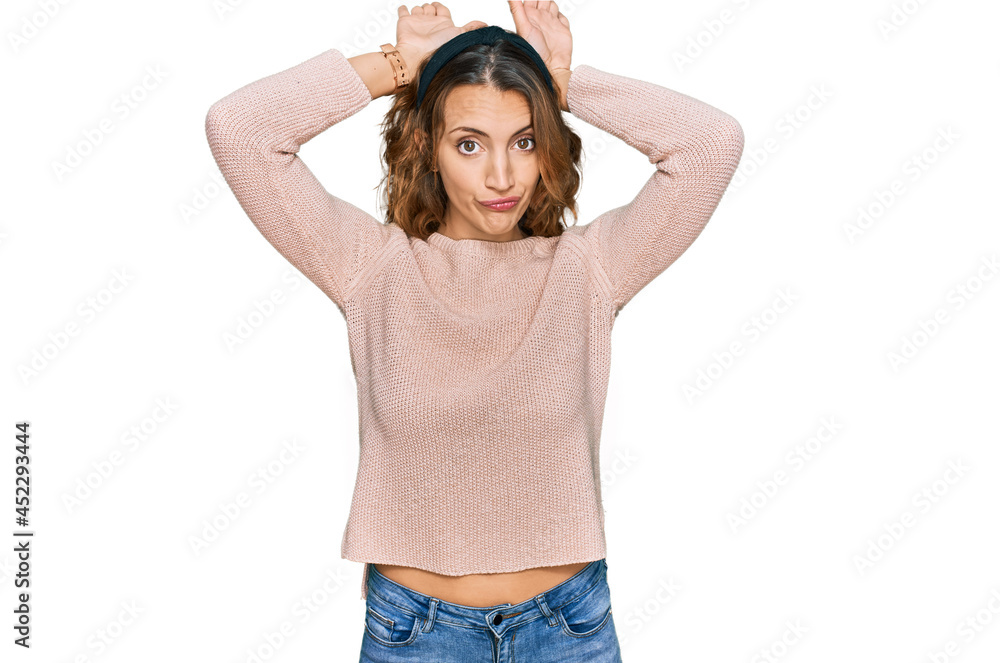 Beautiful young caucasian woman wearing casual sweater doing bunny ears gesture with hands palms looking cynical and skeptical. easter rabbit concept. Beautiful young caucasian woman wearing casual sweater doing bunny ears gesture with hands palms looking cynical and skeptical. easter rabbit concept.