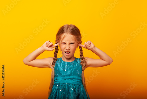 Portrait of a little girl screaming with an open mouth and a crazy expression. Surprised or shocked faces