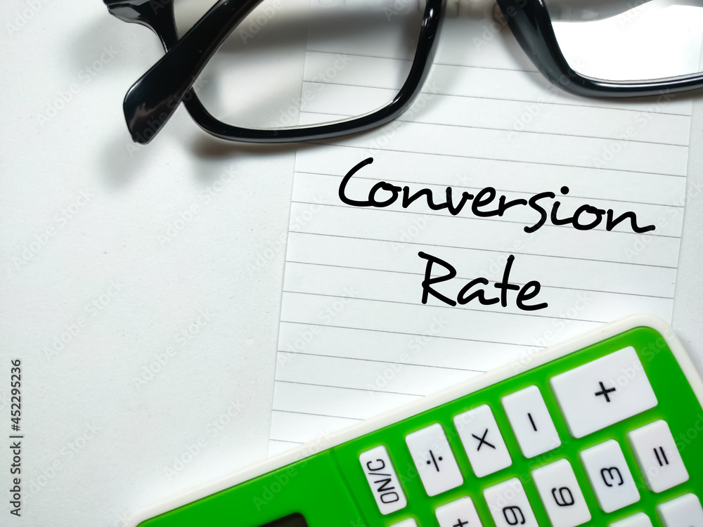 Business concept.Text Conversion Rate writing on notepaper with glasses and calculator on white background. Business concept.Text Conversion Rate writing on notepaper with glasses and calculator on white background.