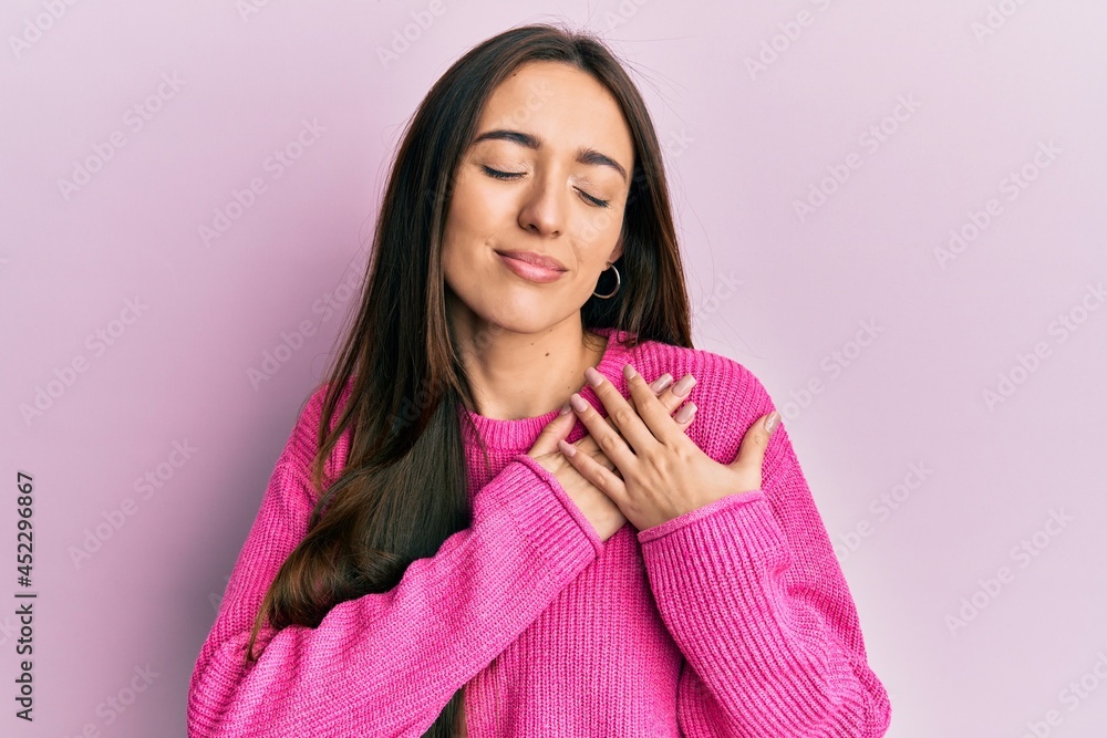 Young hispanic girl wearing casual clothes smiling with hands on chest, eyes closed with grateful gesture on face. health concept. Young hispanic girl wearing casual clothes smiling with hands on chest, eyes closed with grateful gesture on face. health concept.