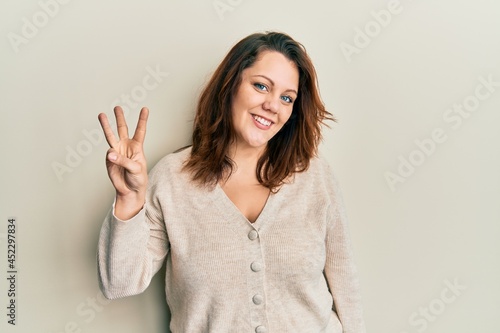 Young caucasian woman wearing casual clothes showing and pointing up with fingers number three while smiling confident and happy.