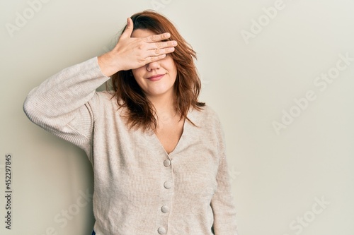 Young caucasian woman wearing casual clothes covering eyes with hand, looking serious and sad. sightless, hiding and rejection concept © Krakenimages.com