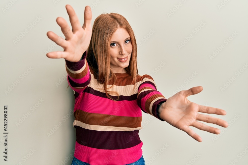 Fototapeta premium Young irish woman wearing casual clothes looking at the camera smiling with open arms for hug. cheerful expression embracing happiness.