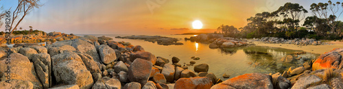 Panorama of sunrise over the ocean at Bay of Fires. Orange lichen covered rocks. Tasmania, Australia. No people, copy space. photo