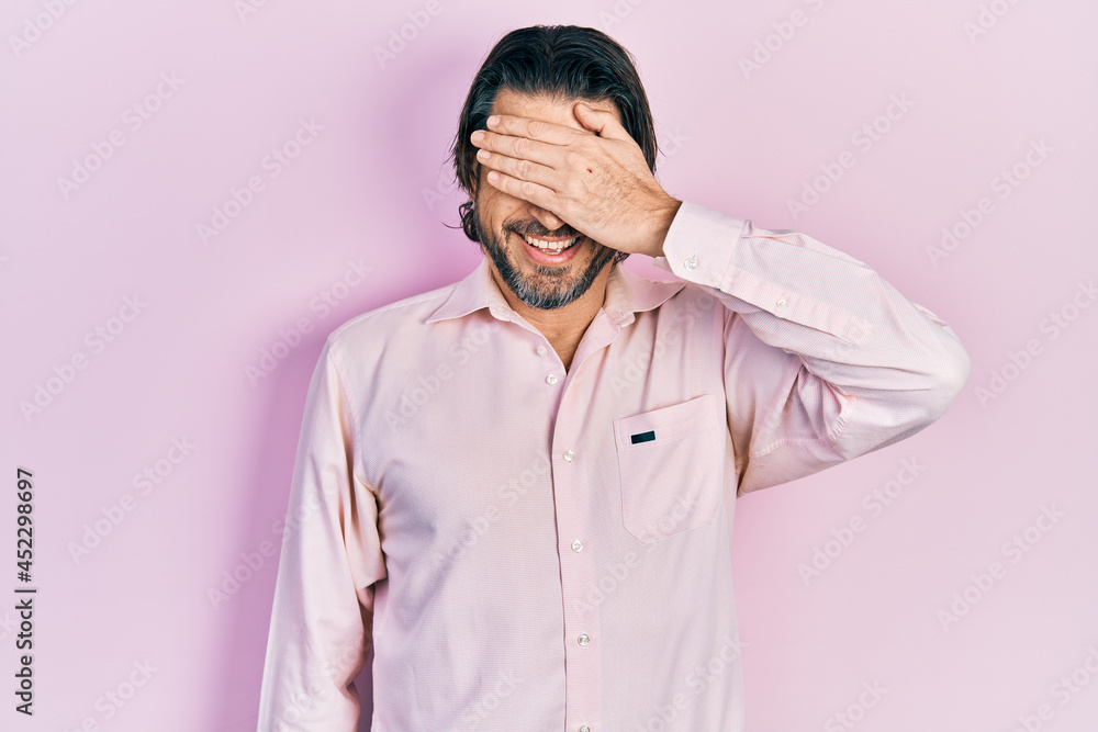 Fototapeta premium Middle age caucasian man wearing casual clothes smiling and laughing with hand on face covering eyes for surprise. blind concept.