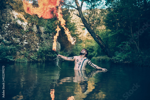 Man in a river blowing fire