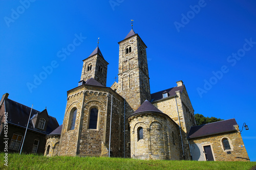 Obraz na płótnie View on roman basilica and monastery from 11th century with two towers on green hill against blue summer sky - Sint Odilienberg, Netherlands w salonie
