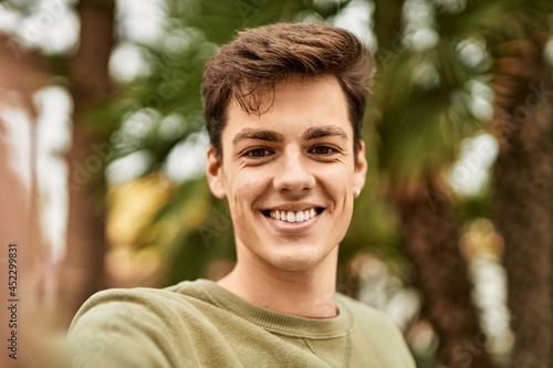 Young hispanic man smiling happy making selfie by the camera at the city.