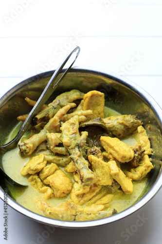 Top View Opor Ceker Ayam Kampung with Tofu on a Bowl. Opor is Yellow Curry typically from Melayu, Indonesia, or Malaysia Cuisine. Copy Space for Text