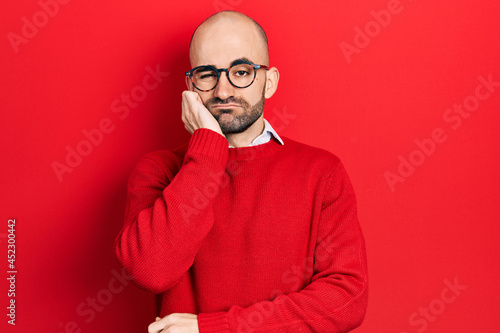 Young bald man wearing casual clothes and glasses thinking looking tired and bored with depression problems with crossed arms.