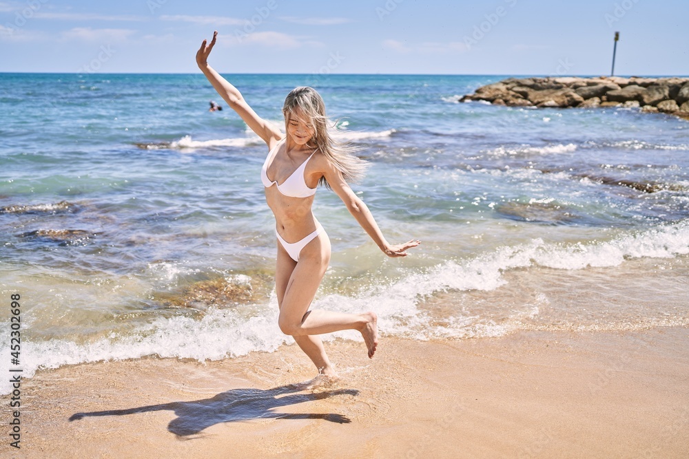 Young chinese girl wearing bikini standing at the beach. Young chinese girl wearing bikini standing at the beach.