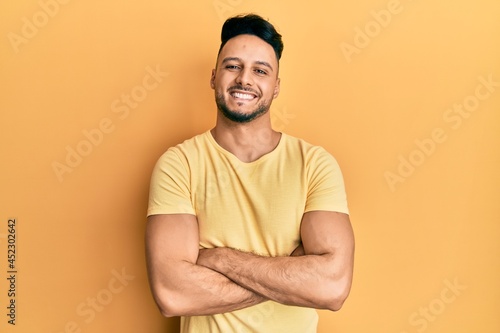 Young arab man wearing casual clothes happy face smiling with crossed arms looking at the camera. positive person.