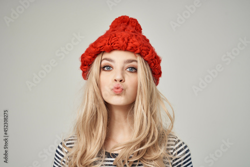 blonde in fashionable clothes Red Hat light background Lifestyle