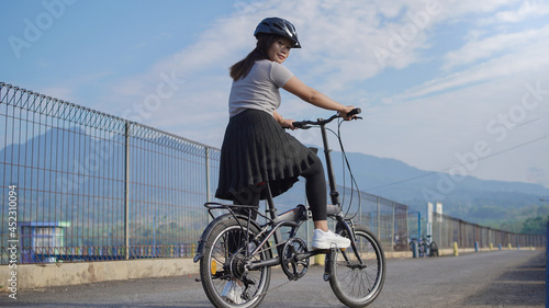Canvas Print young asian woman enjoying cycling when stopped in summer morning