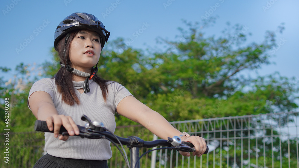 Obraz premium young asian woman enjoying cycling in summer morning