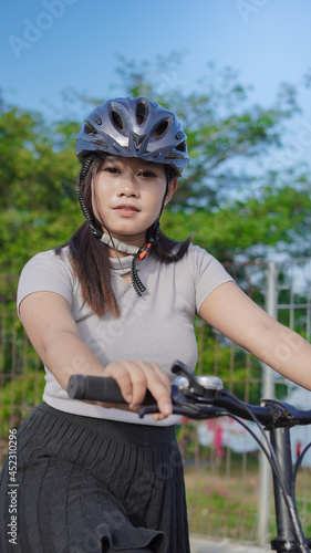 young asian woman enjoying cycling when stopped in summer morning