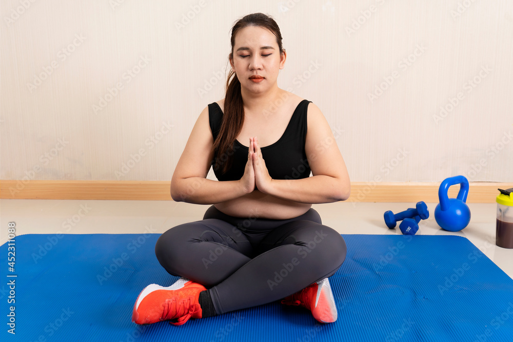 Fototapeta premium Young fat woman practicing yoga at home. sports motivation and healthy lifestyle. sports concept, training endurance, Healthy weight loss. Wellness concept