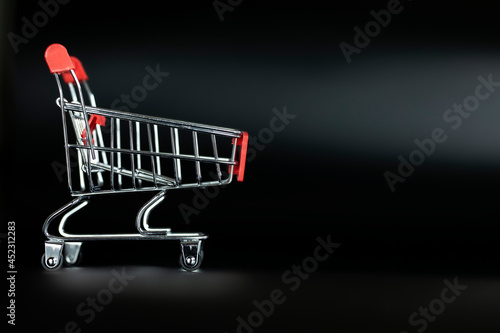 Shopping cart empty on black background with copy space, shopping and black Friday concept.