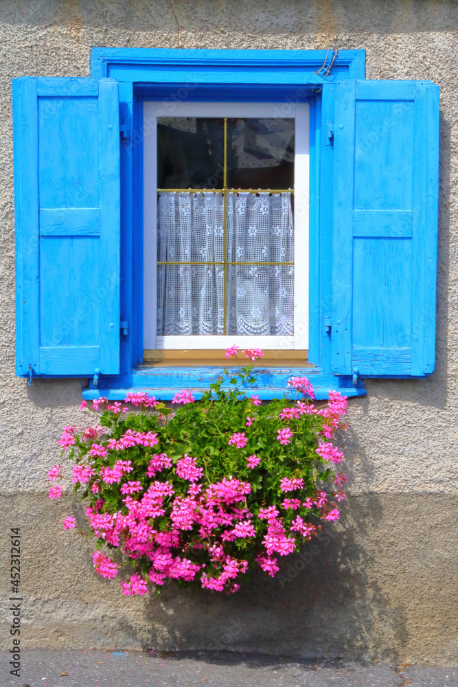 Finestra di legno azzurra con fiori,  Wooden pale blue window with flower