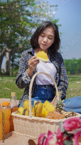 Young asian woman eating watermelon on vacation in park