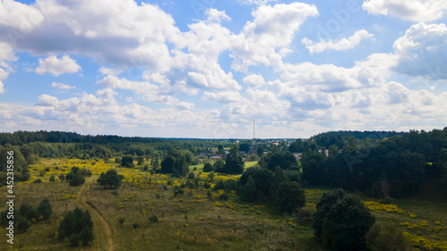 Summer rural landscape with the blue sky, clouds, meadow and forest. Aerial view. Countryside concept.