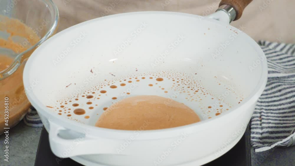 Step by step. Frying pumpkin pancakes batter on a white frying pan. Step by step. Frying pumpkin pancakes batter on a white frying pan.