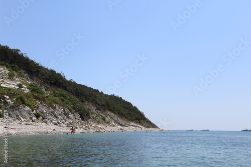 Seascape on the shore with tourists resting in hot sunny weather. © Снежана Кудрявцева