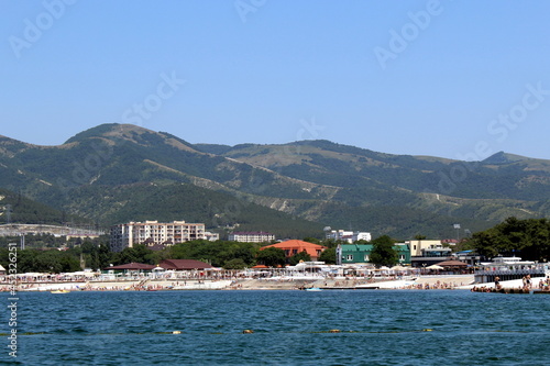 Seascape. View from the sea. Summer beach with many people vacationing by the sea on a hot day.