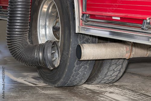 Fire truck exhaust tailpipe with diesel fume extractor hose system. Concept of emission control, firefighter health and safety in firehouse photo