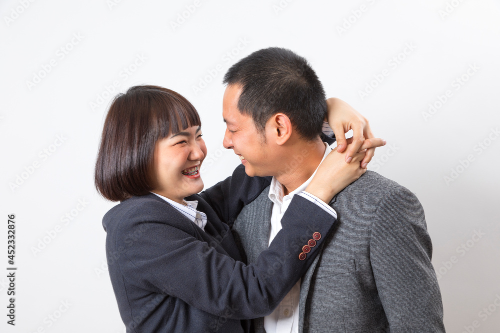 Asians executive businessman and businesswoman smile and hugging standing on white background. Asians executive businessman and businesswoman smile and hugging standing on white background.