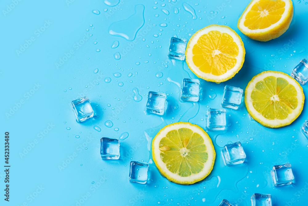 juicy fresh yellow lemon slices and ice cubes on a blue background. Top view, flat lay juicy fresh yellow lemon slices and ice cubes on a blue background. Top view, flat lay