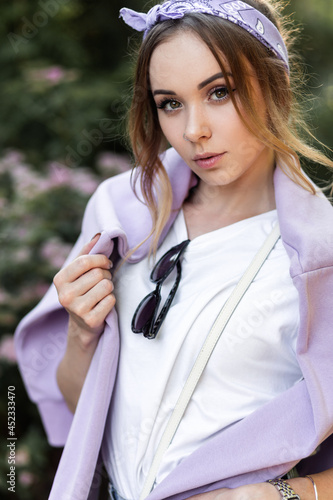 Wallpaper Mural Portrait of beautiful hipster woman with sunglasses in white t-shirt with purple sweatshirt on nature near flowers Torontodigital.ca