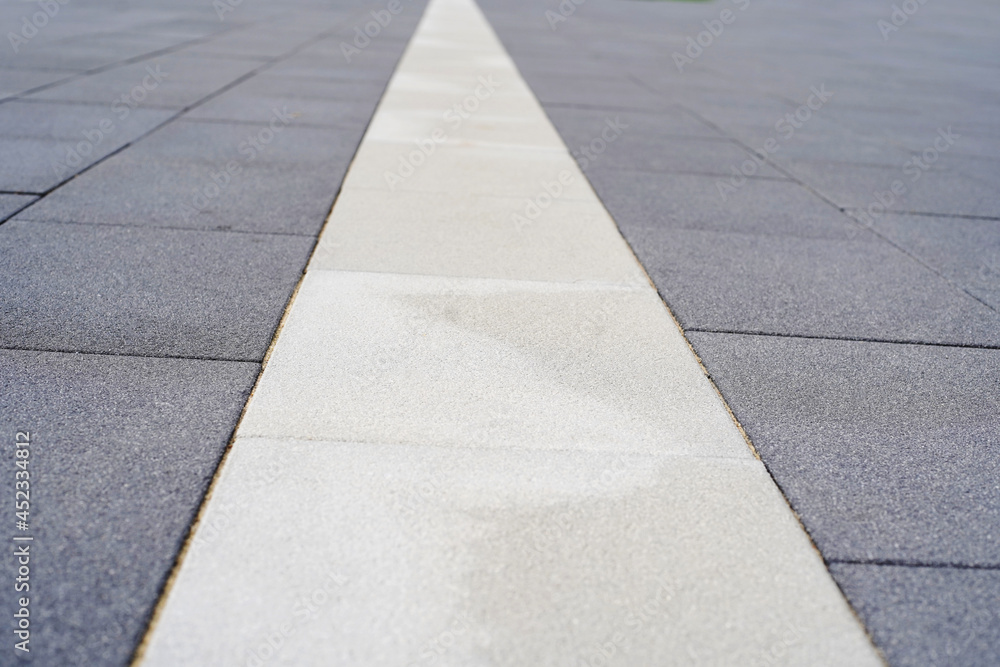 Obraz premium Fragment of granite paving stones with special markings for people with disabilities. Close-up