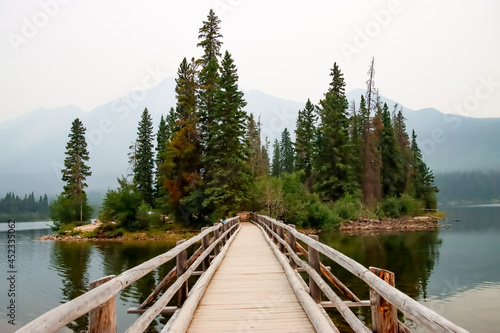 Close up of a wooden pedestrian bridge that leads to a small island on Pyramid lake in Jasper, Alberta