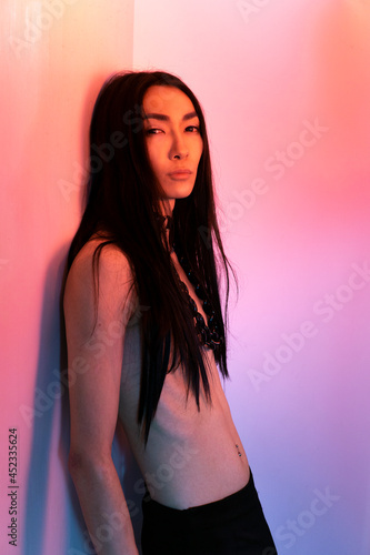Asian androgynous man with long hair posing