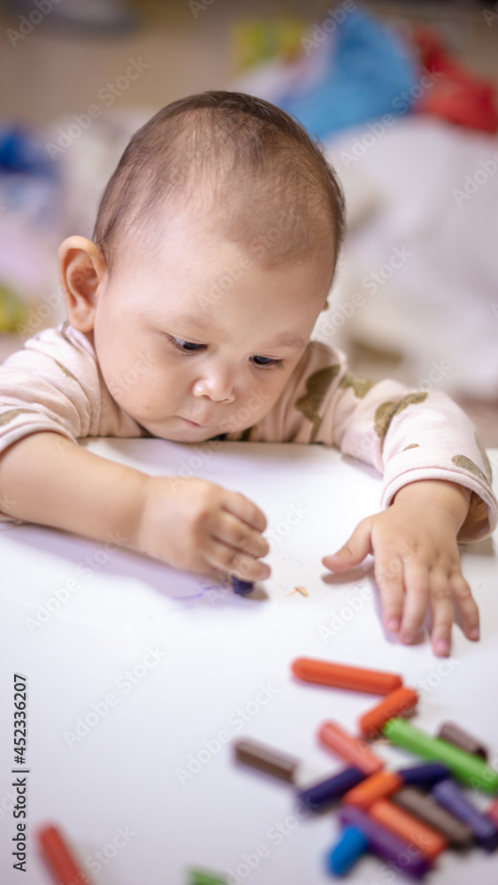Baby Asian Girl drawing and playing as she develops her motor skills Baby Asian Girl drawing and playing as she develops her motor skills