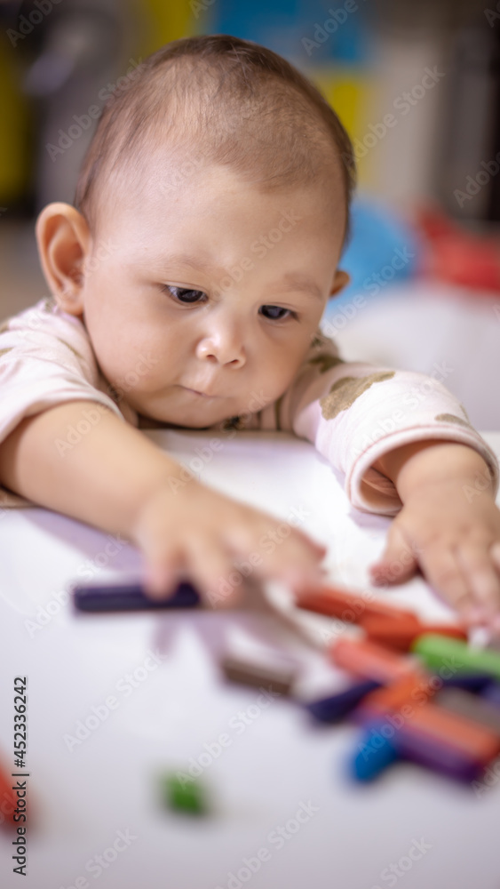 Baby Asian Girl drawing and playing as she develops her motor skills Baby Asian Girl drawing and playing as she develops her motor skills