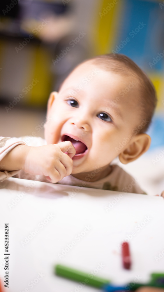 Baby Asian Girl Trying to put crayons into her mouth Baby Asian Girl Trying to put crayons into her mouth
