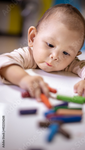 Baby Asian Girl drawing and playing as she develops her motor skills