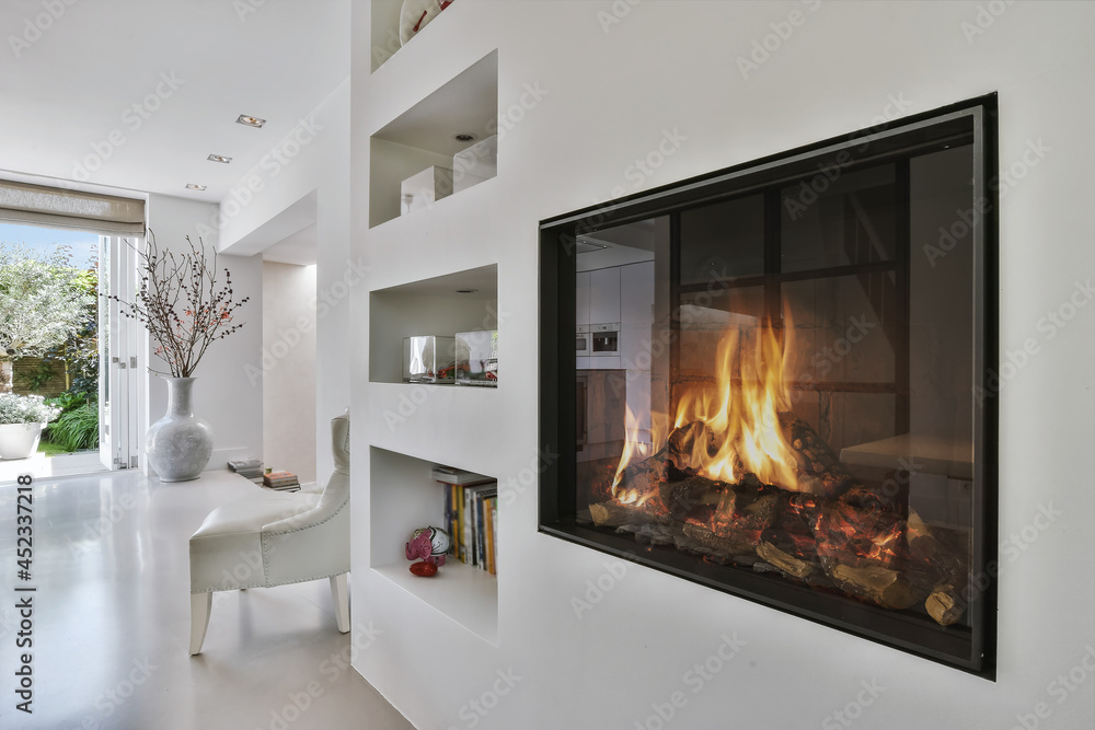 Stylish fireplace in a spacious living room - obrazy, fototapety, plakaty 