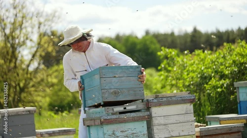 Handsome beekeeper working with honeycombs. Young beeworker in uniform. photo