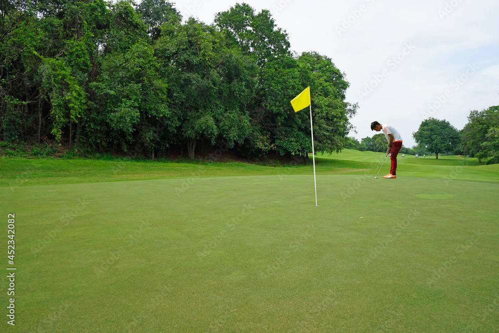 Obraz premium Golfers are putting golf in the evening golf course golf backglound. Golfer hitting golf ball.