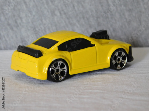 Car miniature  sedan toy for kids withyellow paint and black tires with turbo engine.