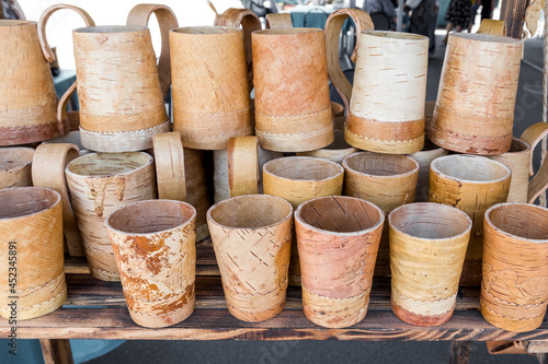 Birch bark glasses and mugs are sold at the folk crafts fair. Russian folk products made of birch bark.