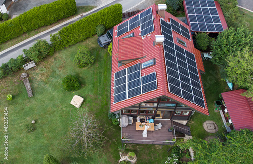 Luftaufnahme Einfamilienhaus mit Garten Balkon und Photovoltaikanlage udn Menschen