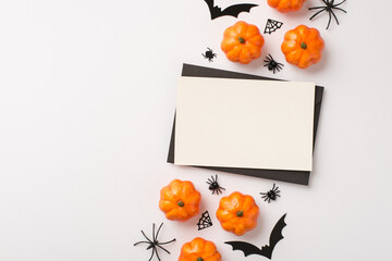 Top view photo of black envelope white card pumpkins spiders web and bats silhouettes on isolated white background with copyspace