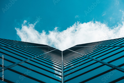 Foto Dramatic perspective on high-rise skyscraper office building with cloudy blue sk