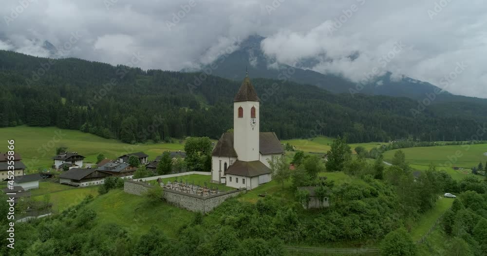 Aerial Lockdown Scenic View Of Church Over Green Landscape Against Cloudy Sky - South Tyrol, Italy Aerial Lockdown Scenic View Of Church Over Green Landscape Against Cloudy Sky - South Tyrol, Italy