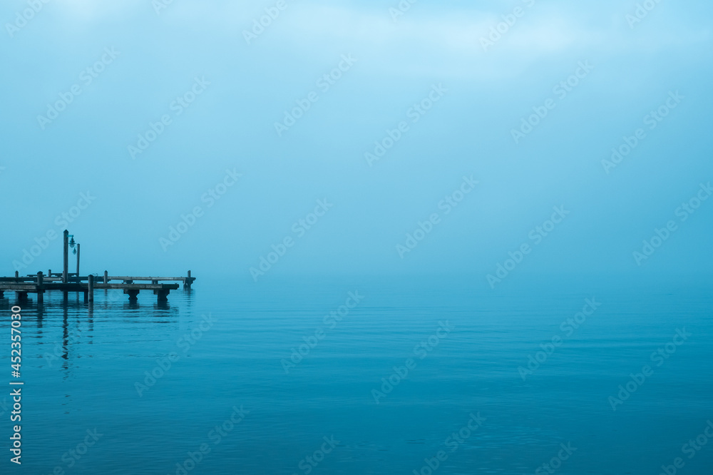 Dock on a lake on a foggy day with calm water